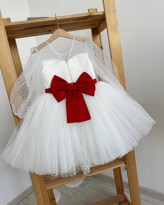 White polka dot dress with red satin sash and statement bow at the back