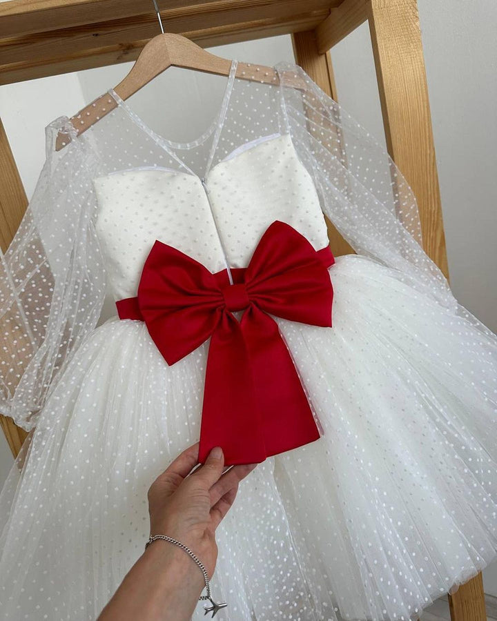 White polka dot dress with red satin sash and statement bow at the back