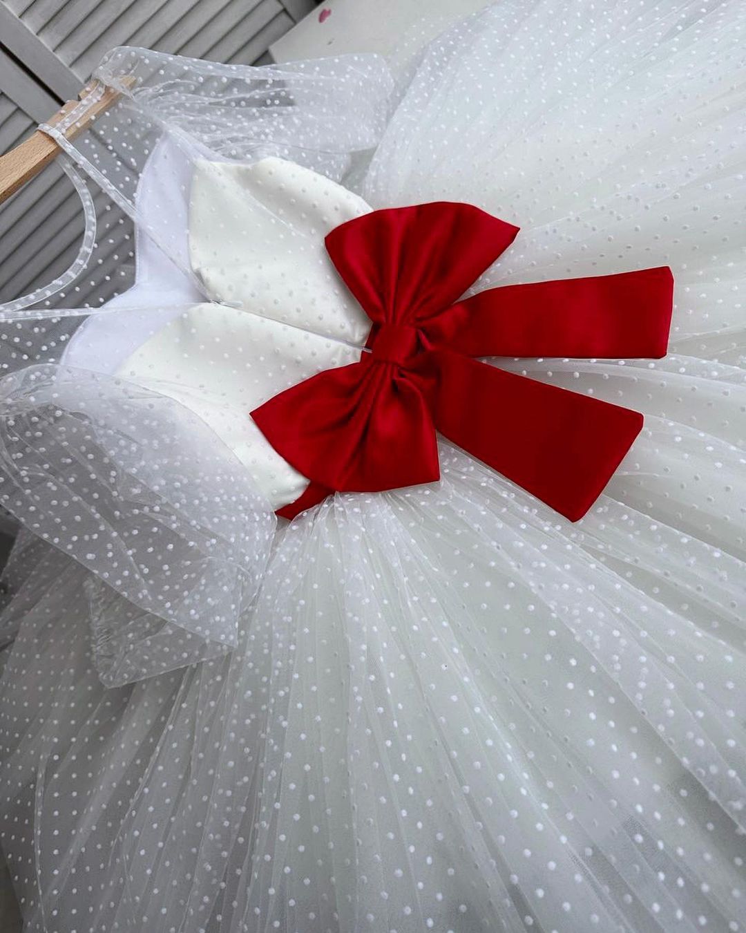 White polka dot dress with red satin sash and statement bow at the back